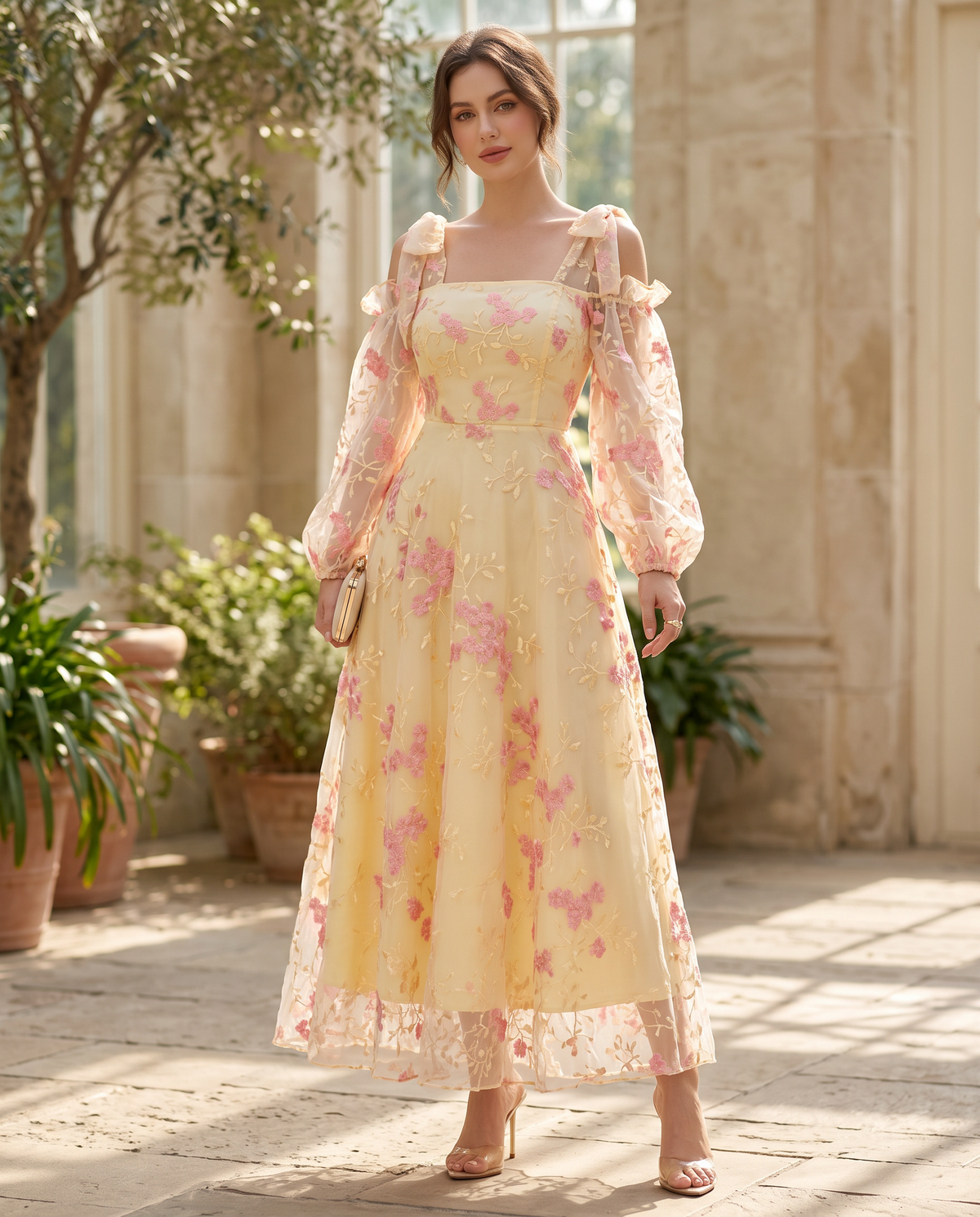 Adult model wearing the BIA Élodie Bishop Maxi in butter-yellow embroidered organza with pink florals, full-length front view.