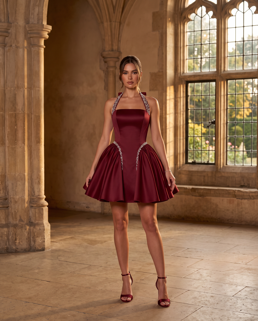Adult model wearing the BIA Vesper Halter Mini in burgundy satin with rhinestone trim, full-length front view.
