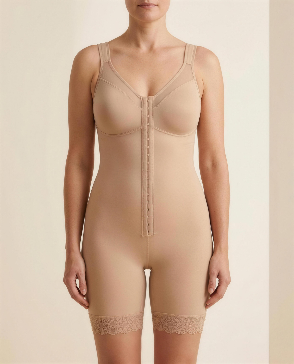 The Verity Lace-Trim Shaping Layer in warm beige, front view showing the mesh V neckline and hook-and-eye front placket