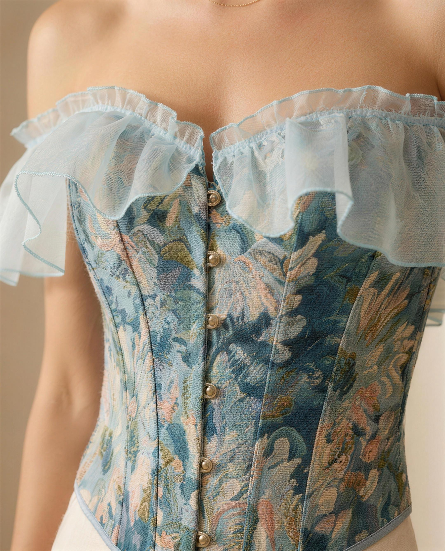 Close detail of the woven tapestry floral, boning channels, antique-gold buttons and organza flounce