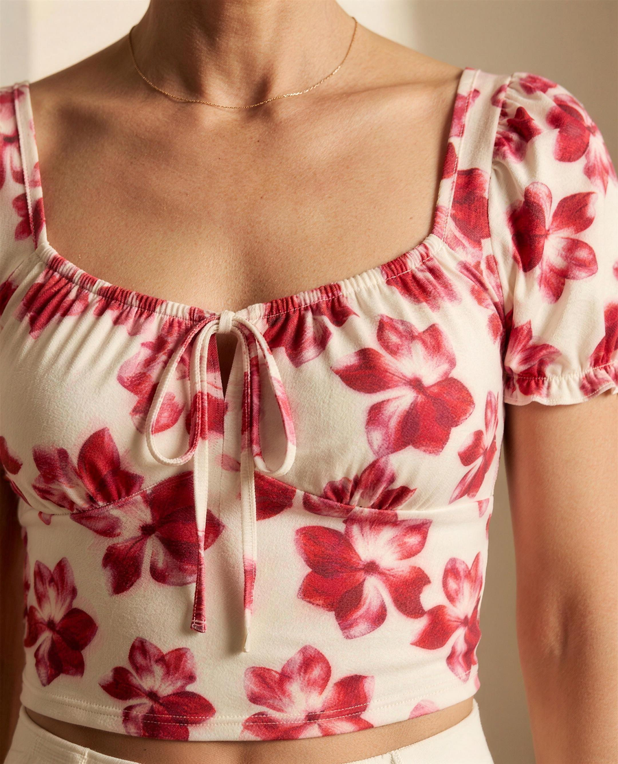 Close detail of the gathered sweetheart neckline, drawstring bow and watercolour floral jersey