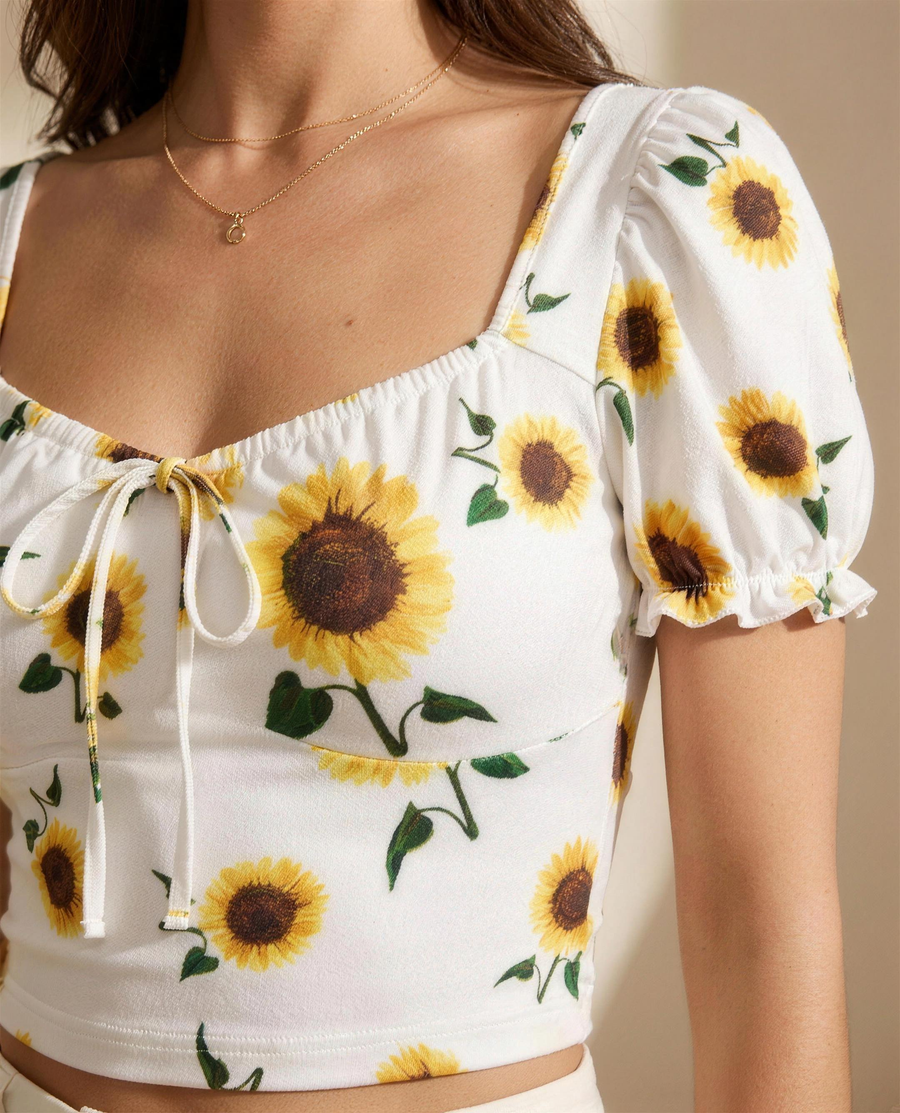 Close detail of the sunflower print, gathered sweetheart neckline and drawstring bow