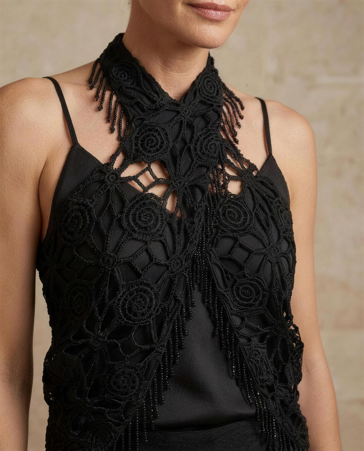 Close detail of the guipure crochet rosettes, open bars and beaded fringe