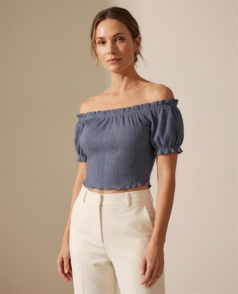 The Colette Broderie Crop Top in slate blue, off-shoulder elasticated neckline with short puff sleeves