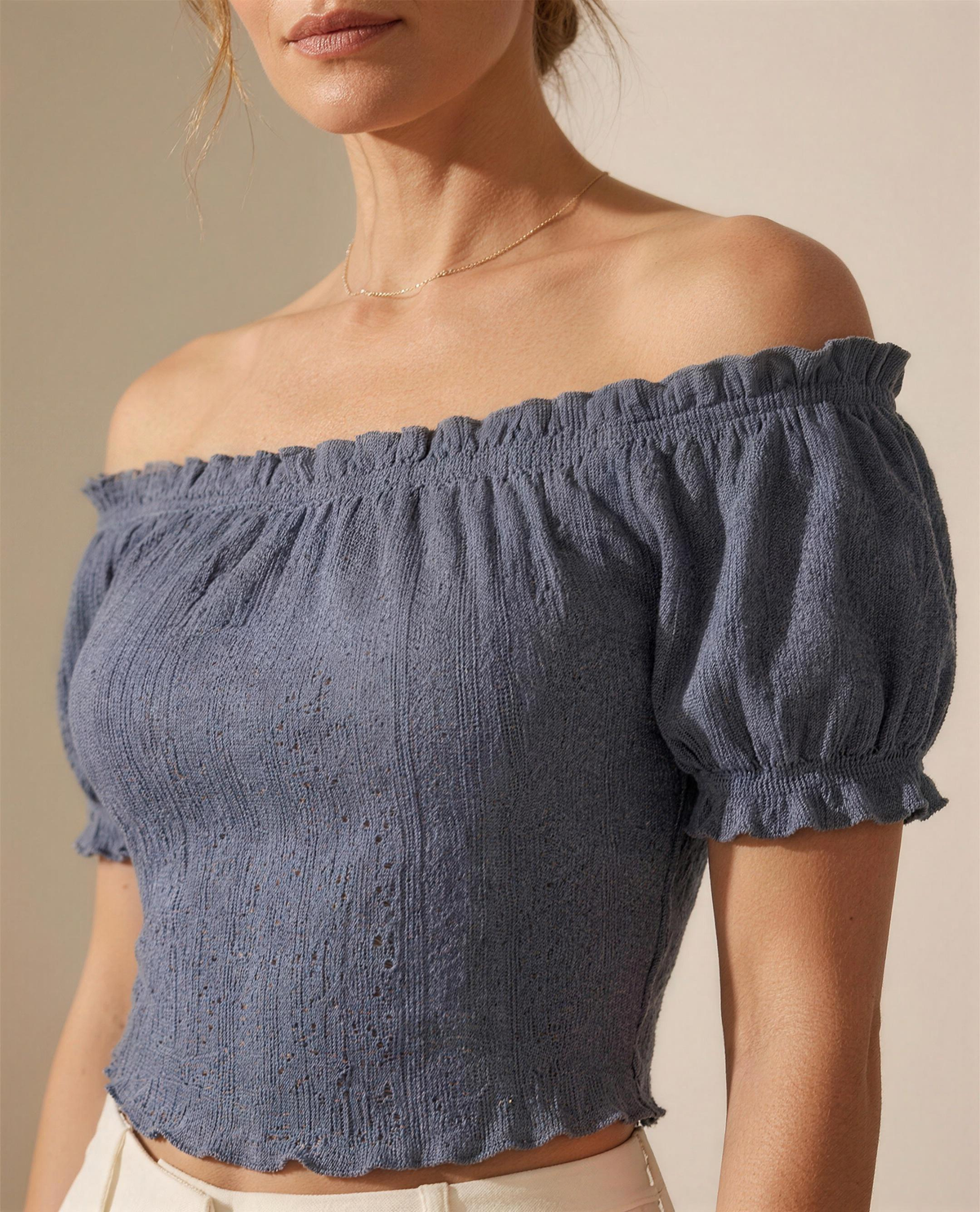 Close detail of the eyelet and broderie knit texture and lettuce-edged hem