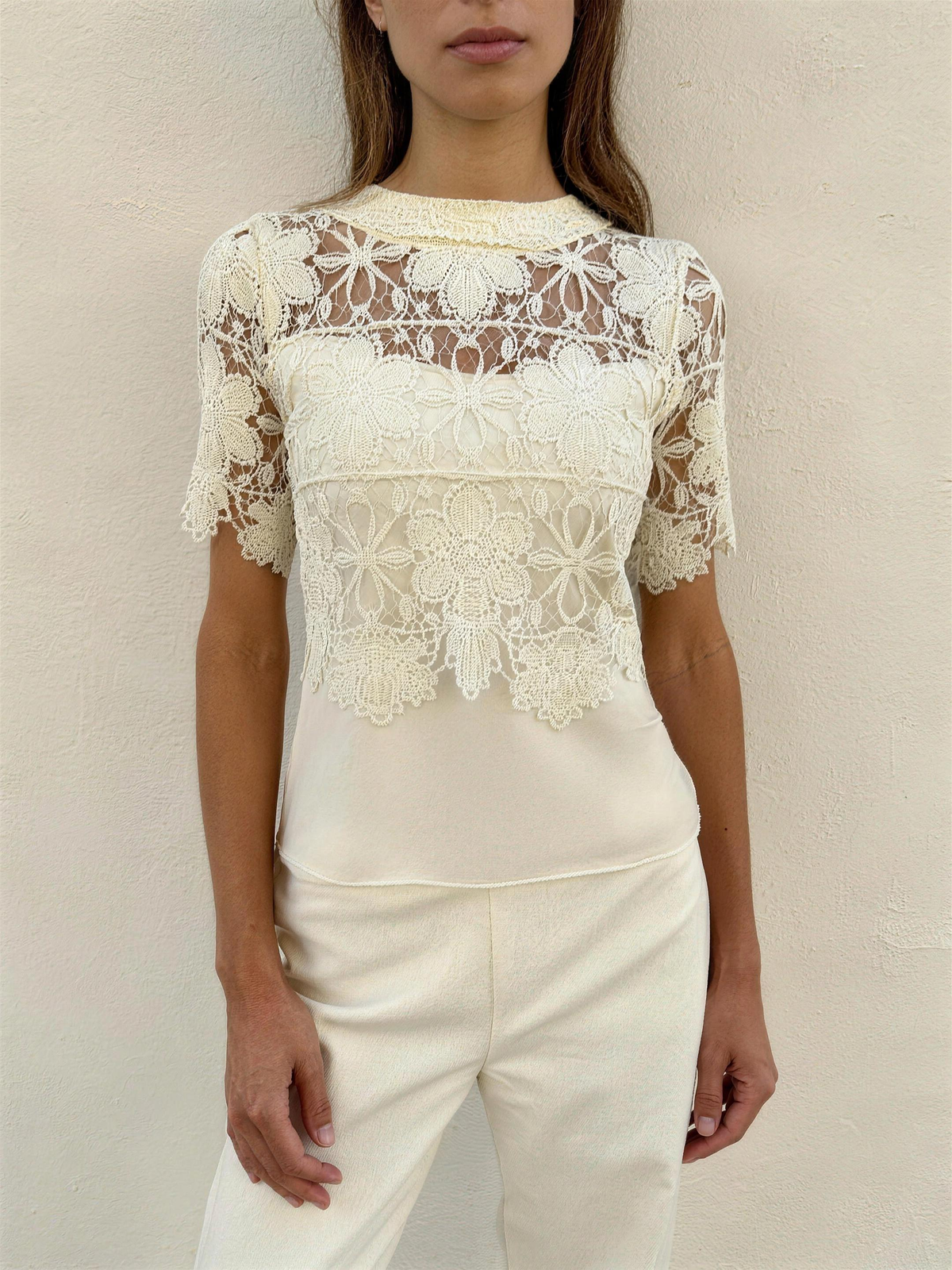 The Coralie Guipure Lace Top in cream, full front view showing the high lace-band neck, scalloped short sleeves and cropped hem over a cream camisole